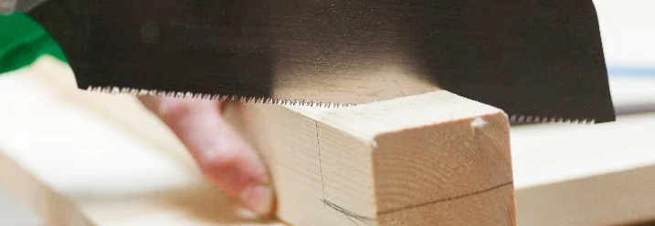 Person sägt Holz mit Japansäge